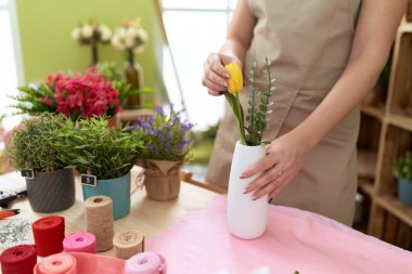 Çiçekçide çiçek tutan güzel bir kadın.