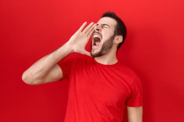 Latin asıllı genç adam, günlük kırmızı tişört giyip el ele tutuşarak bağırıyor ve çığlık atıyordu. iletişim konsepti. 