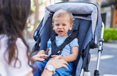 Anne ve oğlu bebek arabasında oturup sokakta ağlıyorlar.
