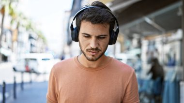 Şehir sokaklarında sakallı, kulaklık takan yakışıklı bir İspanyol..