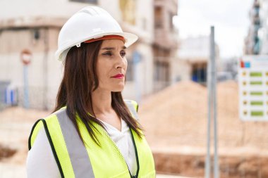 Young beautiful hispanic woman architect standing with relaxed expression at street