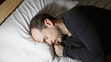 Geceleri karanlık bir yatak odasında uyuyan sakallı kel bir adam huzuru ve istirahatı tasvir ediyor..