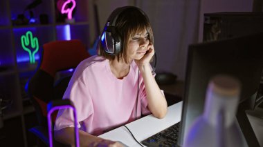 Genç, güzel İspanyol kadın flaması oyun odasında bilgisayar kullanarak oyun oynamak sıkıcı.