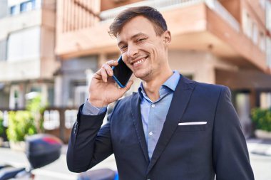 Young man business worker smiling confident talking on smartphone at street