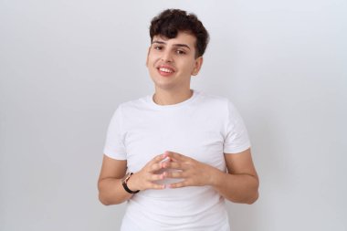 Gündelik beyaz tişörtler giyen, gülümseyen, rahat ve neşeli genç bir adam. Başarı ve iyimserlik 