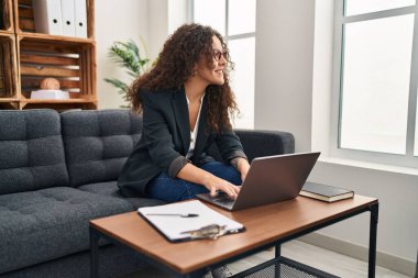 Young beautiful hispanic woman business worker using laptop working at office
