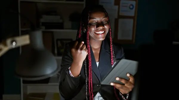 自信的非洲裔美国女性员工在办公室里用触摸板庆祝商业的成功 一个笑容可亲 像老板一样的获奖者的美丽肖像 在灯光下 她发出光芒 — 图库照片