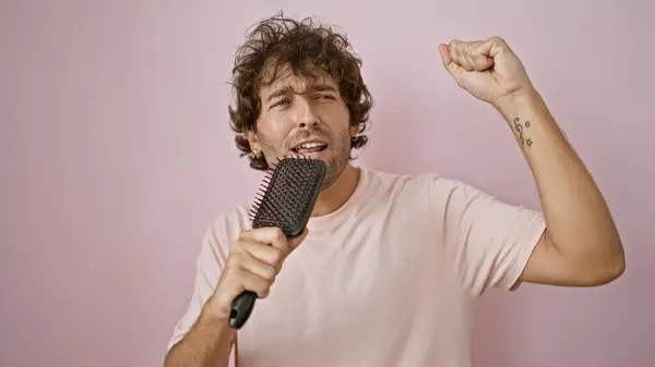 Hispanic Man Singing Hairbrush Isolated Pink Background Exuding Carefree Joyful — Stock Photo, Image