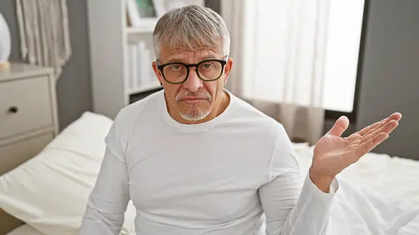 Mann Mittleren Alters Mit Brille Sitzt Schlafzimmer Und Äußert Verwirrung — Stockfoto