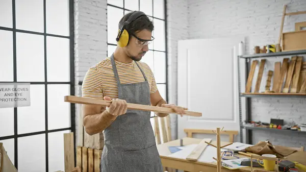Hispanic Man Examining Wood Well Lit Carpentry Workshop — Stock Photo, Image