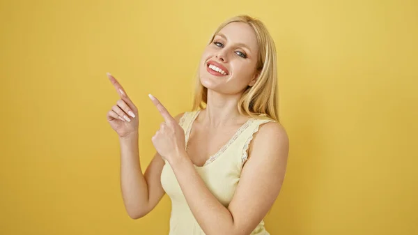Veselá Blondýnka Ukazující Vzhůru Zatímco Stojí Žlutém Pozadí Ztělesňující Pozitivitu — Stock fotografie