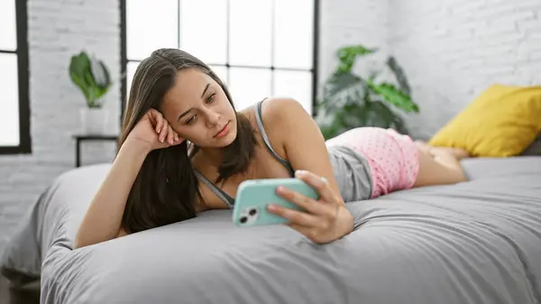 Upset Young Hispanic Woman Lying Comfortably Bed Using Her Smartphone — Stock Photo, Image