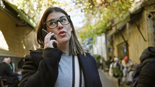 Young Brunette Woman Talks Smartphone While Walking Historic Urban Street — Stock Photo, Image