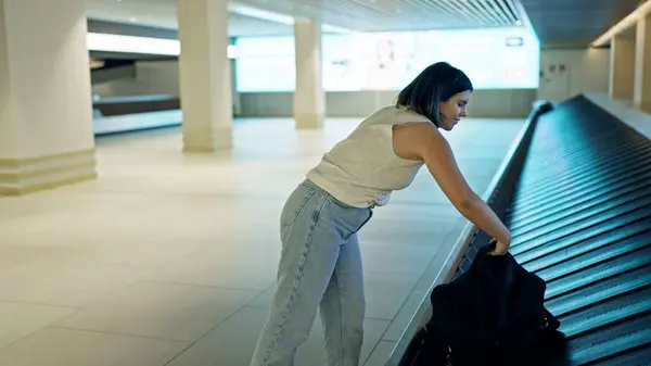 在机场 年轻美丽的他的惊慌失措的女人从行李传送带提包 — 图库照片