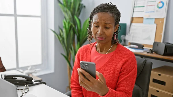 African American Woman Uses Smartphone Modern Office Setting Showcasing Technology — Stock Photo, Image