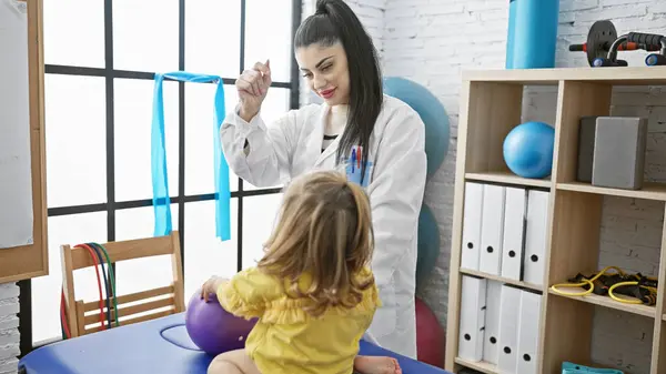 Ženský Pediatr Dohlíží Holčičku Posilovacími Kapelami Terapeutické Místnosti — Stock fotografie