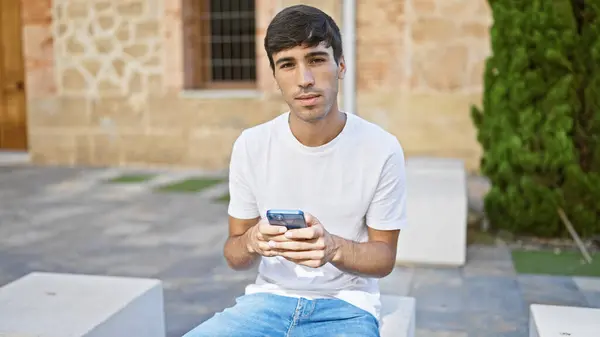 Молодой Латиноамериканец Использует Смартфон Серьезным Выражением Лица Парке — стоковое фото