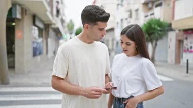 Bir çift, sessiz bir şehir caddesinde, çağdaş bir şehir ortamında bağlanmışlığı tasvir eden akıllı bir telefonla karşılaşır..