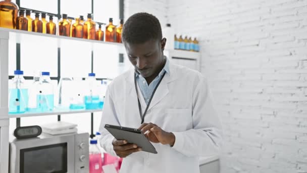 실험실 코트에 아프리카 과학자는 제품과 실험실에서 태블릿을 — 비디오