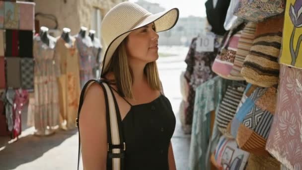 Μια Χαμογελαστή Γυναίκα Φορώντας Ένα Sunhat Καταστήματα Μια Παραδοσιακή Αγορά — Αρχείο Βίντεο