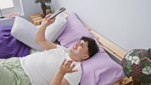 Ein Junger Mann Entspannt Sich Bett Bei Einem Videoanruf Mit — Stockvideo