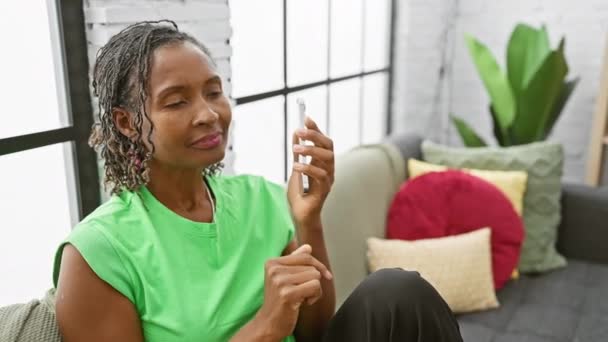 Una Alegre Mujer Afroamericana Conversa Teléfono Una Acogedora Sala Estar — Vídeo de stock