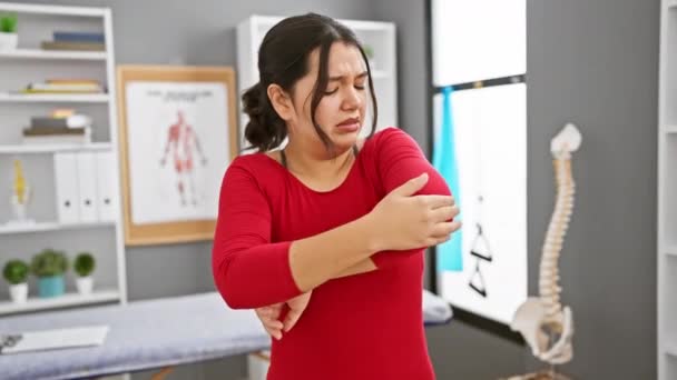 Young Hispanic Woman Red Top Expresses Pain Indoor Clinic Setting — Stock Video