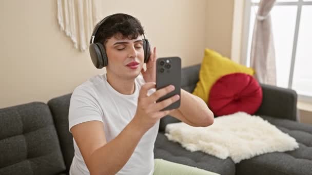 Young Man Headphones Using Smartphone Cozy Living Room Exemplifies Modern — Stock Video
