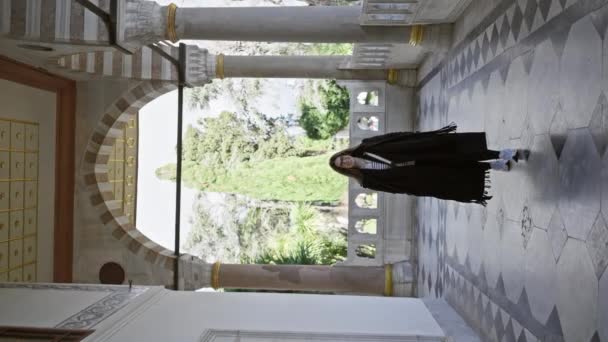 Femeie Zâmbitoare Într Haină Neagră Explorează Arhitectura Istorică Posibil Palatul — Videoclip de stoc