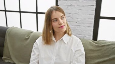 Kadın ve erkek, aydınlık, modern bir oturma odasında kahve ile samimi bir anı paylaşıyor..