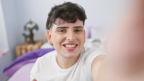 Usmívající Mladý Muž Vezme Selfie Dobře Osvětlené Ložnici Ukazuje Ležérní — Stock video