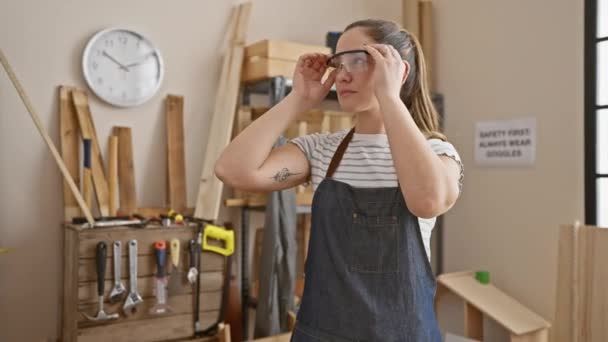 Uma Mulher Pensativa Macacão Ajusta Seus Óculos Uma Oficina Carpintaria — Vídeo de Stock