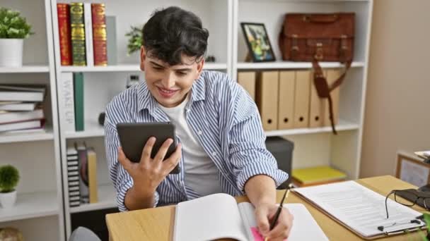 Young Man Striped Shirt Engaged Multitasking Tablet Taking Notes Organized — Stock Video
