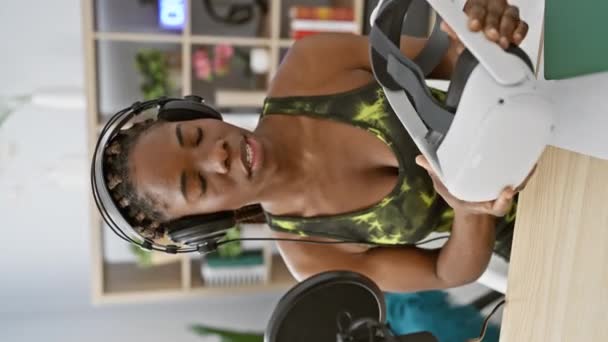 Afroamerykanka Warkoczami Nosząca Słuchawki Studiu Trzymającym Słuchawki Wirtualnej Rzeczywistości — Wideo stockowe