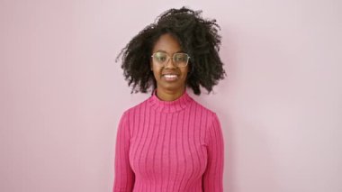 Gözlüklü mutlu Afro-Amerikan kadın, başarı için başparmak işareti yapıyor! Onaylayıcı ve pembe yerine neşeli görünüyor.