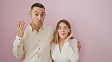 Neşeli, güzel bir çift, ellerini havaya kaldırarak büyük zaferlerini kutluyorlar! Pembe izole edilmiş arka planda muzaffer bir sevinç paylaştıkça, hayret verici ifadeler.