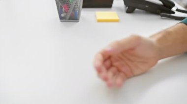 İki meslektaş, bir erkek ve bir kadın, iş yerinde destekleyici bir tokalaşma içinde, takım çalışmasını ve işbirliğini sembolize ediyorlar..