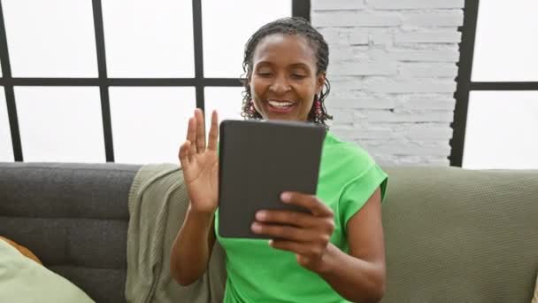 Mujer Negra Sonriente Usando Tableta Sofá Interior Para Comunicación Ocio — Vídeo de stock
