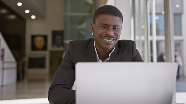 Χαμογελώντας Αφρικανός Κοστούμι Χρησιμοποιώντας Φορητό Υπολογιστή Στο Σύγχρονο Εσωτερικό Του — Αρχείο Βίντεο