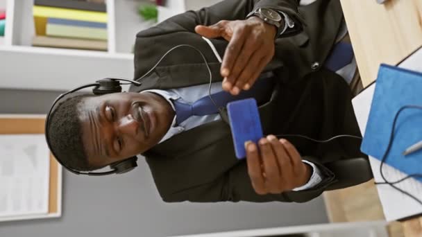 Takım Elbiseli Kulaklıklı Modern Bir Ofiste Mavi Karta Gülümseyen Afrikalı — Stok video