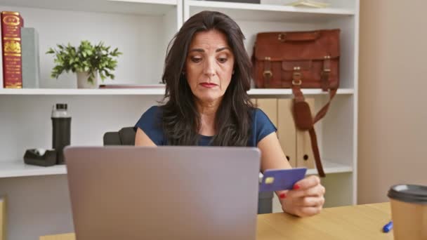 办公室里一个专心致志的惊慌失措的女人用笔记本电脑拿着信用卡 在网上购物或做财务工作 — 图库视频影像
