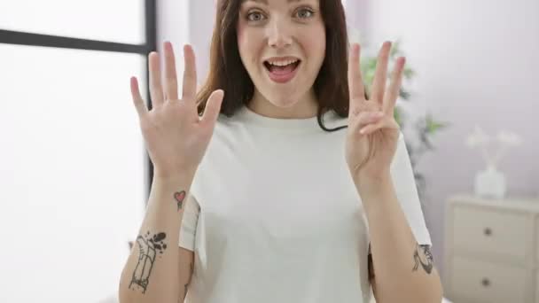 Молода Жінка Піжамі Сидить Ліжку Показуючи Вказуючи Пальцями Номер Вісім — стокове відео