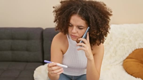 一位忧心忡忡的年轻女子在舒适的客厅里进行孕期测试时 一边打电话一边说着话 — 图库视频影像