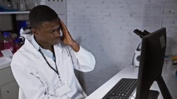 Afrikai Amerikai Tudós Laborköpenyben Fejfájást Fejt Egy Laboratóriumban Számítógéppel Berendezéssel — Stock videók