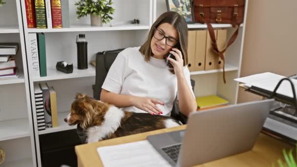 在现代办公环境中 西班牙裔女性与电话和宠物狗肩负着多项任务 — 图库视频影像