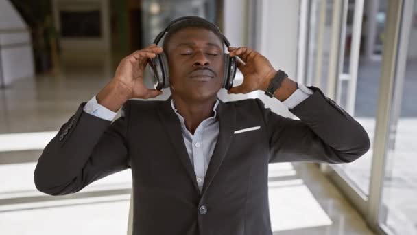 Uvolněný Africký Muž Rád Hudbu Sluchátky Jasném Kancelářském Interiéru — Stock video