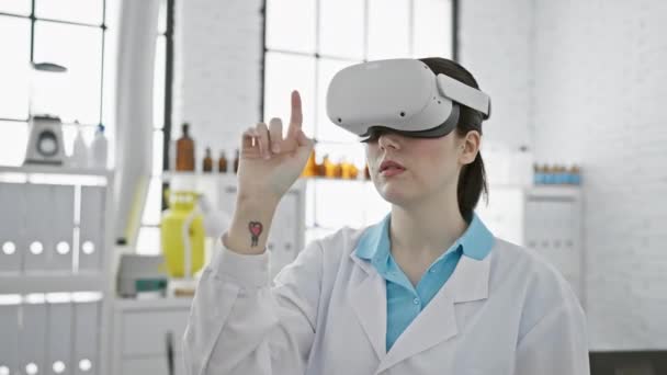 Uma Jovem Mulher Jaleco Usa Auscultadores Realidade Virtual Num Laboratório — Vídeo de Stock