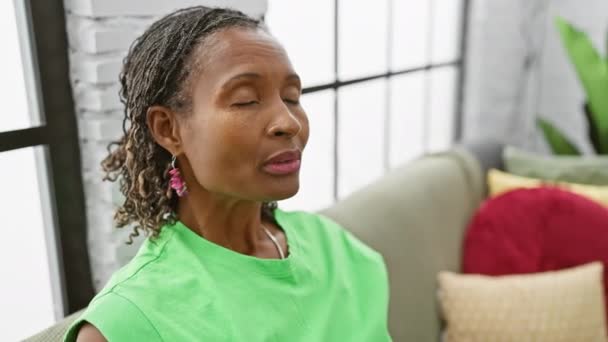Afrikansk Amerikansk Kvinna Slappnar Med Slutna Ögon Ett Mysigt Vardagsrum — Stockvideo