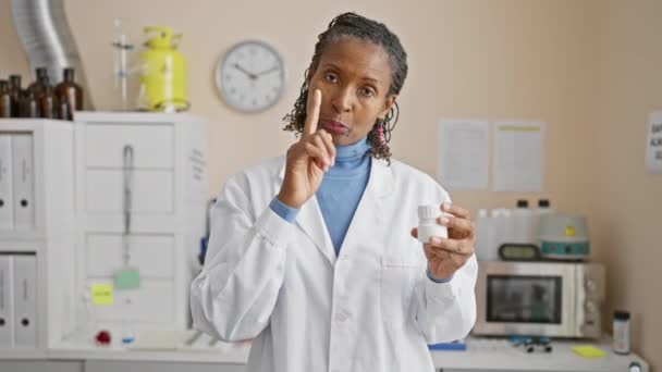 在实验室内服药物的成熟的非洲女药剂师 — 图库视频影像
