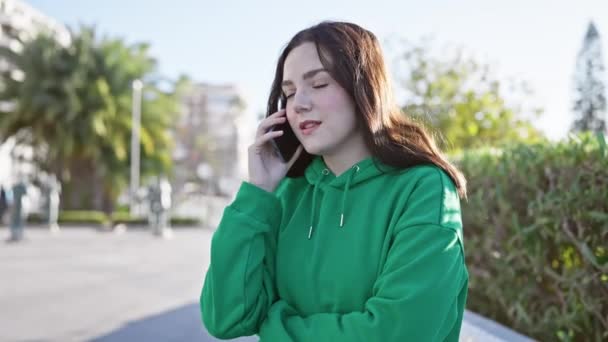 Молодая Женщина Разговаривает Смартфоне Городском Парке Окруженный Зеленью Городскими Элементами — стоковое видео